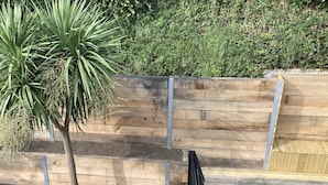 A wooden planter box with a tree and a metal gate.