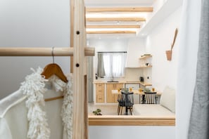 A modern, compact living space with a kitchenette, a dining area, and a sleeping area. - Adama's Suites Naxos (Naxos)