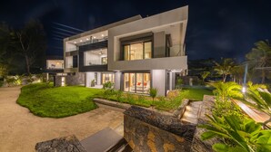 A modern two-story house with a well-maintained lawn, a stone pathway, and a hammock in the garden. - Pointe d'Azur by Horizon Holidays (Grand-Baie)