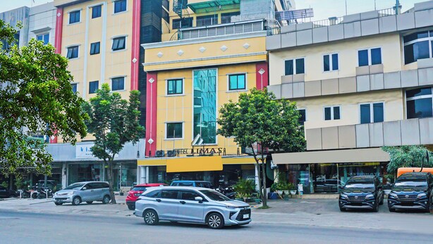 Un hôtel à plusieurs étages, doté d’une façade jaune, de nombreuses fenêtres et d’une entrée imposante.