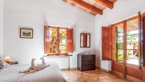 A bedroom with a bed, a dresser, a window with open shutters, and a view of the outdoors. - Villa Martorell, 3 bedroom villa near crystalline beaches of Cala Sant Vicenç (Pollença)