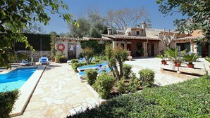 A pool area with lounge chairs, a lifebuoy, and a stone patio. - Villa Martorell, 3 bedroom villa near crystalline beaches of Cala Sant Vicenç (Pollença)