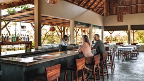 A bar area with wooden furniture and a bar counter.