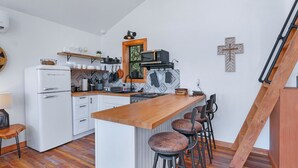 Eine moderne Küche mit einer Holzanbar, weißen Schränken und einem eingebauten Herd.