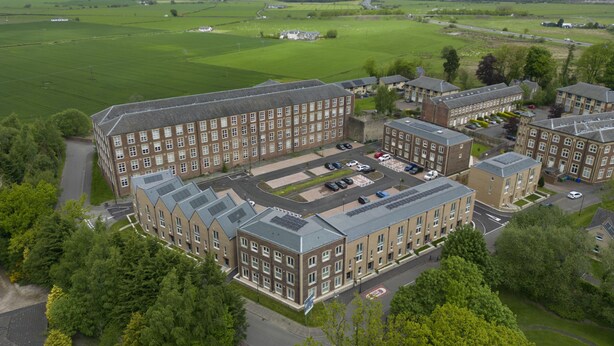 A large, multi-story building with a symmetrical facade, surrounded by green fields and a few scattered trees. - Mhuilinn Apartment  -  an apartment that sleeps 3 guests  in 2 bedrooms (Stirling)