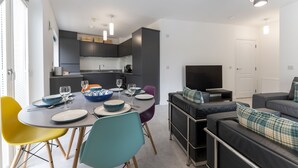 A modern living space with a dining area, kitchen, and seating area. - Mhuilinn Apartment  -  an apartment that sleeps 3 guests  in 2 bedrooms (Stirling)