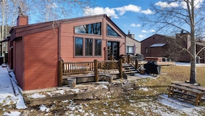 A red wooden cabin with a deck, large windows, and a chimney. - 701B Quail Family & pet friendly 3 bedroom rental private hot tub (Fraser)