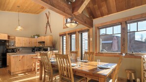 A wooden kitchen with a dining area, large windows, and a ceiling with exposed beams. - 701B Quail Family & pet friendly 3 bedroom rental private hot tub (Fraser)
