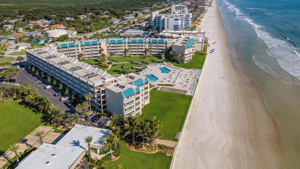 A resort with multiple buildings, a beach, and a parking lot. - Fantastic Oceanview Condo Errol by the Sea 515 (New Smyrna Beach)