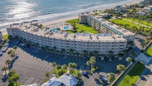 A large, circular hotel with multiple floors, a central courtyard, and a beach view. - Fantastic Oceanview Condo Errol by the Sea 515 (New Smyrna Beach)