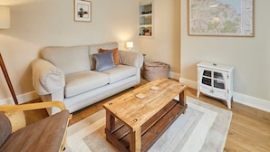 A living room with a sofa, coffee table, and a map on the wall. - Host & Stay | Stone Row (Saltburn-by-the-Sea)