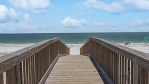 A wooden boardwalk leading to a beach with a clear sky and calm sea. - Beachfront, Amazing Views, Elevator ~ GW 2 (St. Joe Beach)