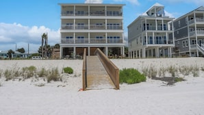 A beachfront hotel with a wooden boardwalk leading to the entrance, multiple balconies, and a clear view of the ocean. - Beachfront, Amazing Views, Elevator ~ GW 2 (St. Joe Beach)