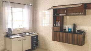 Una cocina con estufa, fregadero y armarios de madera.