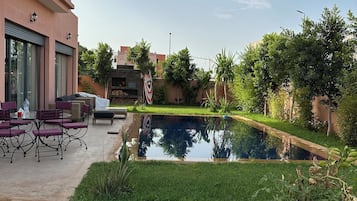 Ein modernes Gebäude mit Schwimmbad, Außenbereich und gepflegtem Rasen.