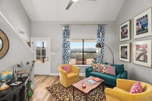 A living room with a sofa, two armchairs, a coffee table, a globe, and framed pictures on the wall. - Hochland Haus Hill Country Views (Boerne)
