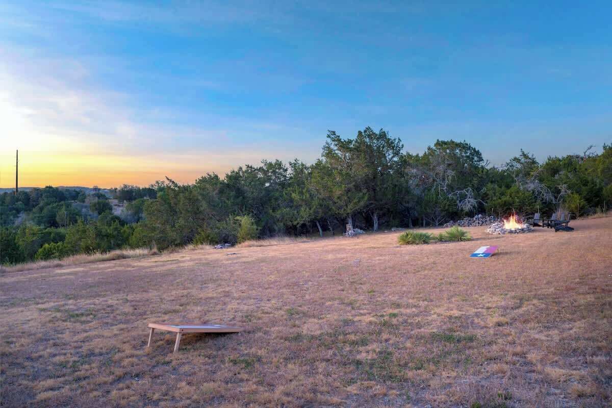 An open field with a fire pit and a bench.