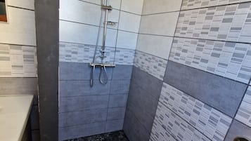 Een douche, een haardroger, handdoeken, toiletpapier