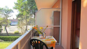 A balcony with a table, chairs, and a vase with flowers. - Comfy Studio in a Charming Residence (San Michele al Tagliamento)