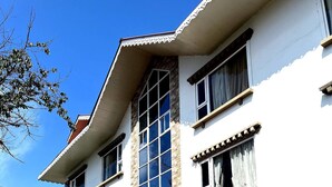 Un bâtiment à deux étages, doté d’une façade en pierre, de grandes fenêtres et d’un toit rouge.