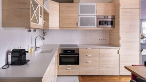 Una cucina moderna con mobili in legno, un forno integrato e una macchina da caffè.