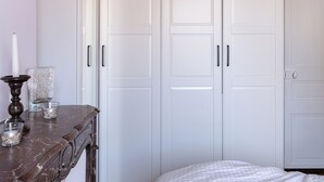 Una camera da letto con un letto, una cassettiera e un armadio.