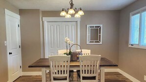 A dining area with a wooden table and chairs, a chandelier, and a door in the background. - Beautifully Updated Home on Oak Trail Drive in IF
 (Idaho Falls)