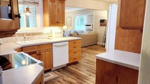 A compact kitchen with wooden cabinets, a white countertop, and a built-in dishwasher. - Beautifully Updated Home on Oak Trail Drive in IF
 (Idaho Falls)