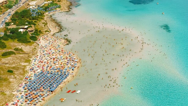 An aerial view of a coastal area with a beach, a small island with a tower, and a road leading to the beach. - Relaxing Le Residenze del Maria Rosaria No2222 (Orosei)