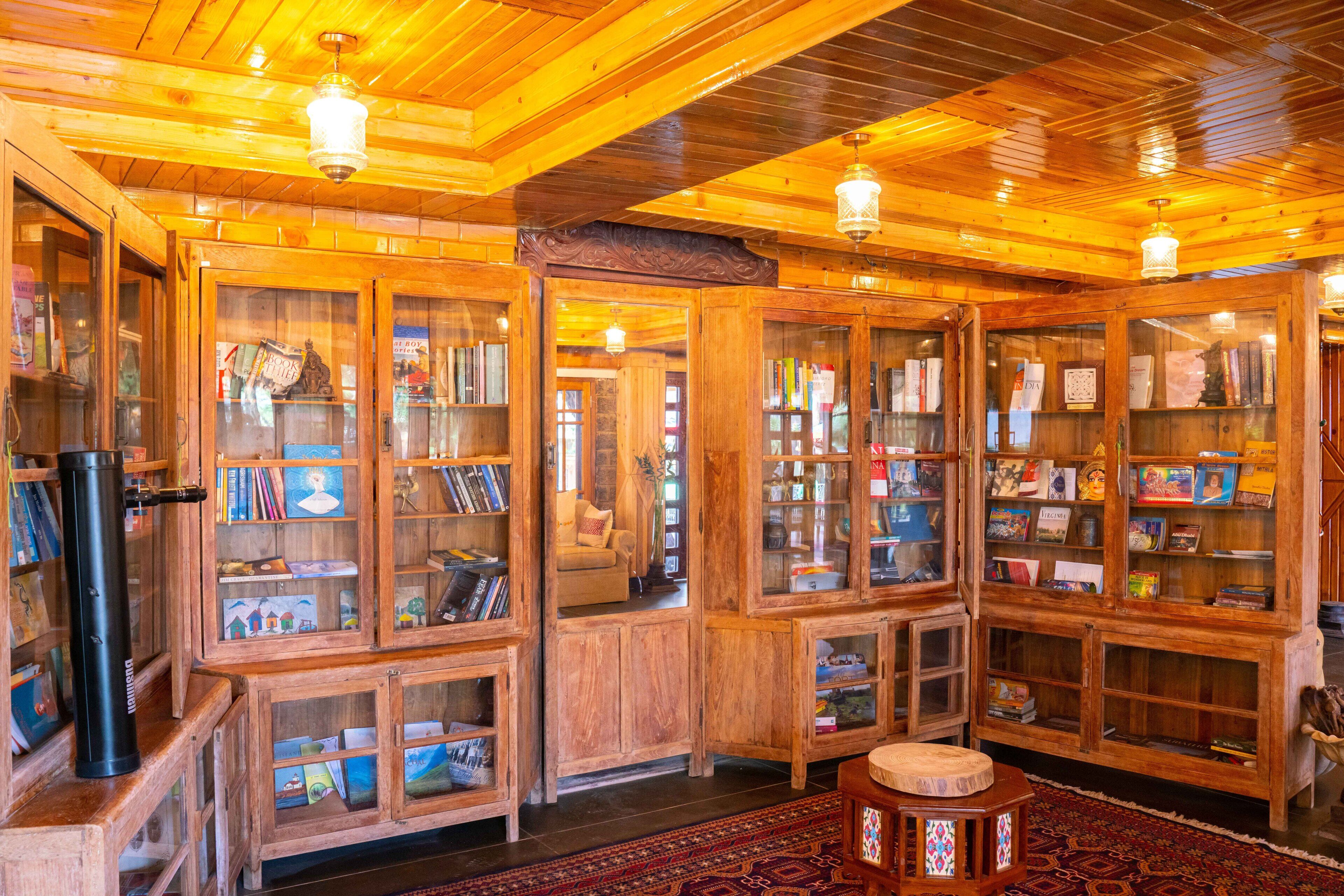 A cozy library with wooden bookshelves and a central seating area.