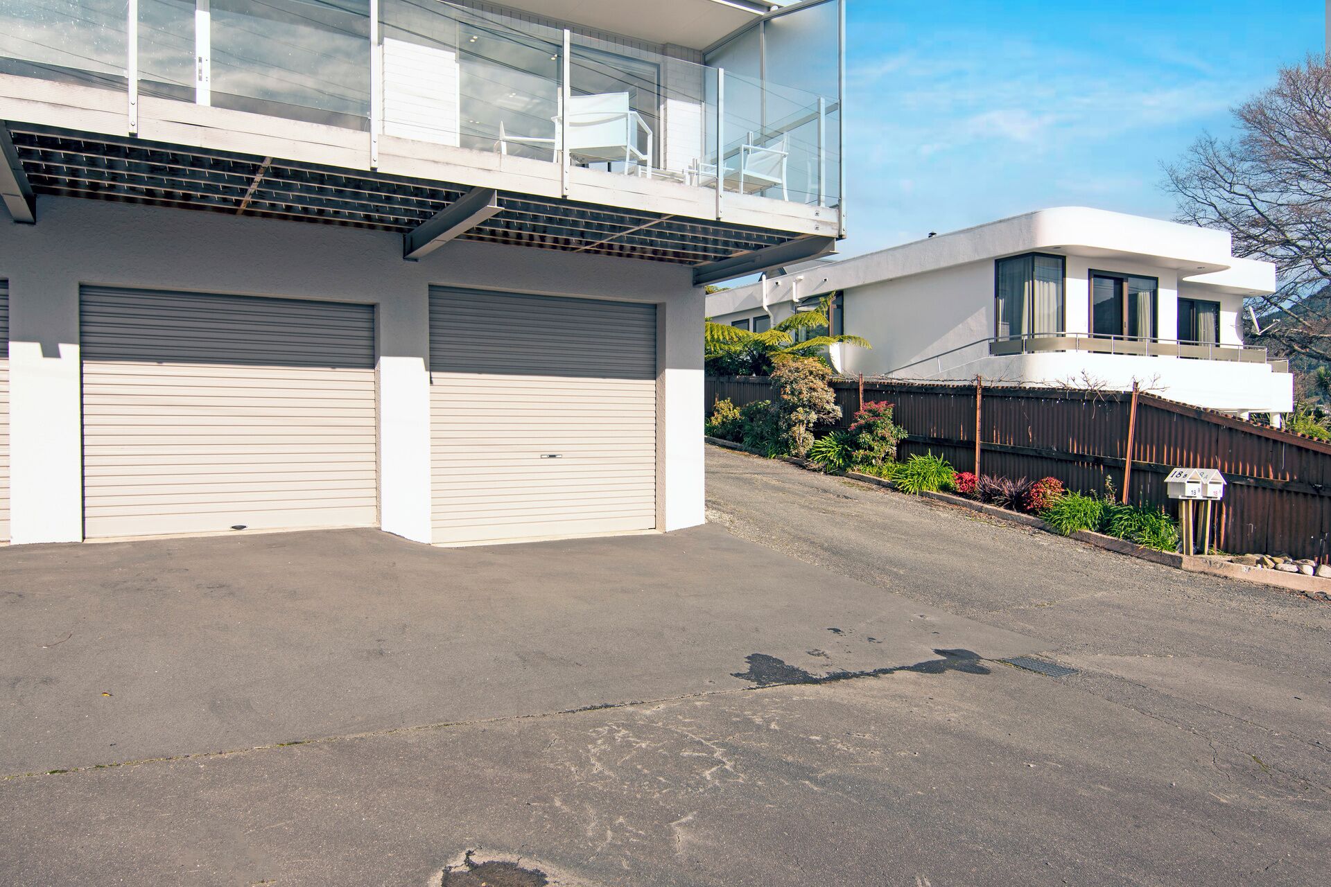 Un immeuble moderne à deux étages, doté d’un garage et d’un balcon.