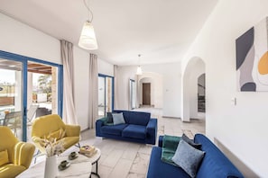 Un soggiorno moderno con divano, poltrona e tavolino.