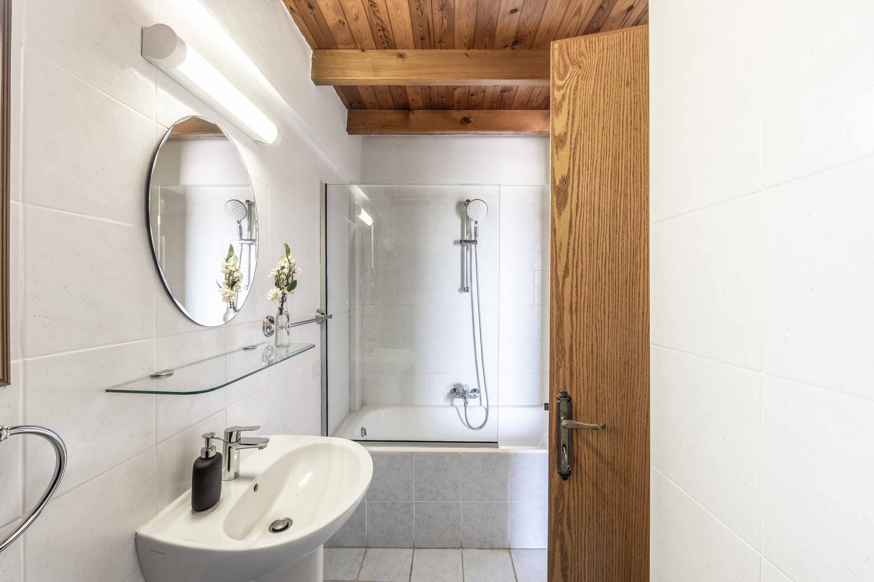 Ein modernes Badezimmer mit Waschbecken, Spiegel und Duschkabine aus Glas.