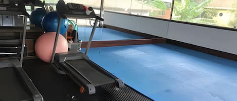 A gym with exercise equipment, including treadmills and exercise balls.