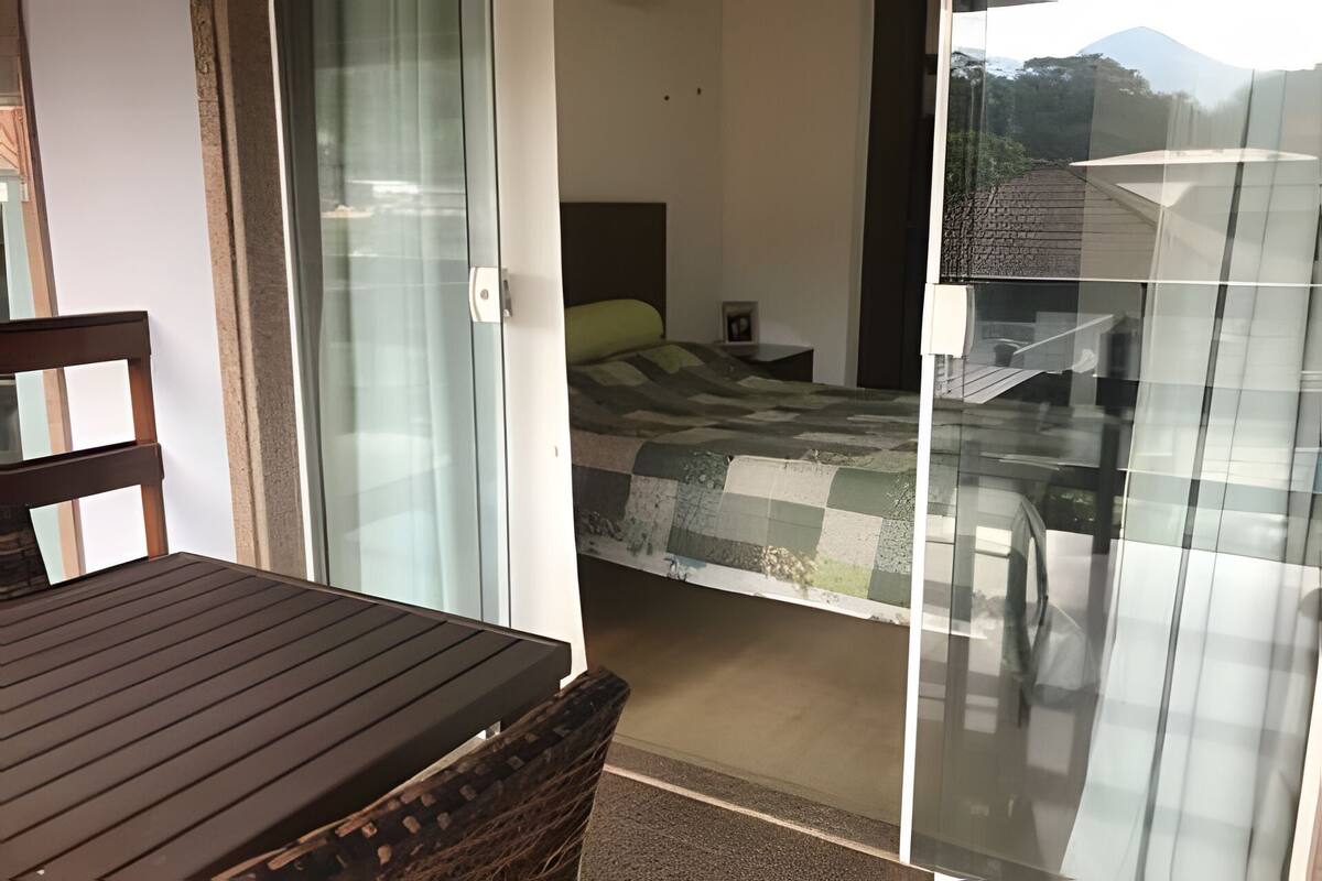 Un dormitorio con una cama, una mesita de noche y una silla.