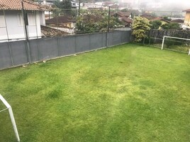 Patio trasero cercado con zona verde y portería de fútbol.