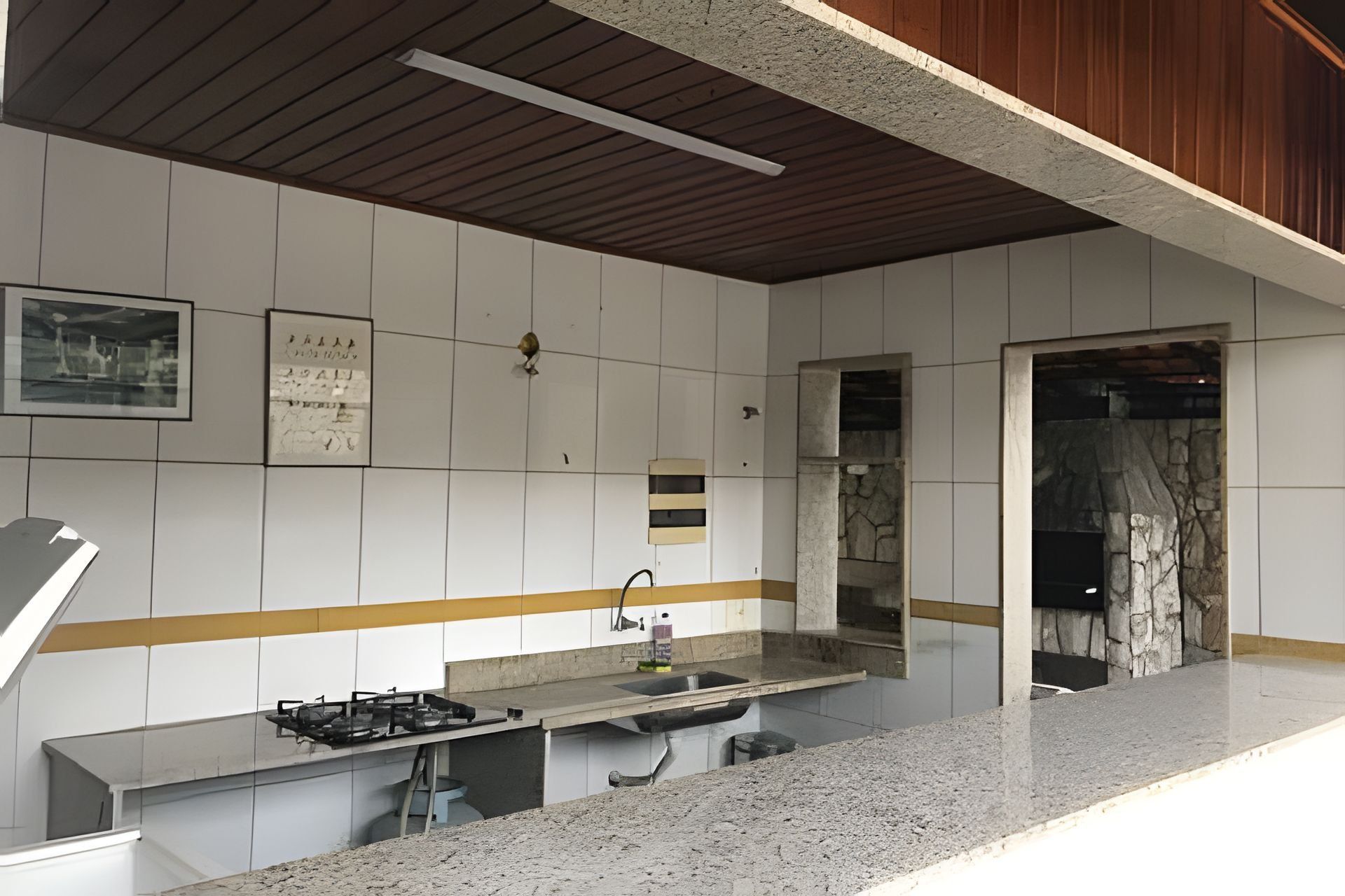 A kitchen with a granite countertop, a gas stove, and a stone backsplash.