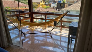 Una hamaca en un balcón con vistas a edificios.