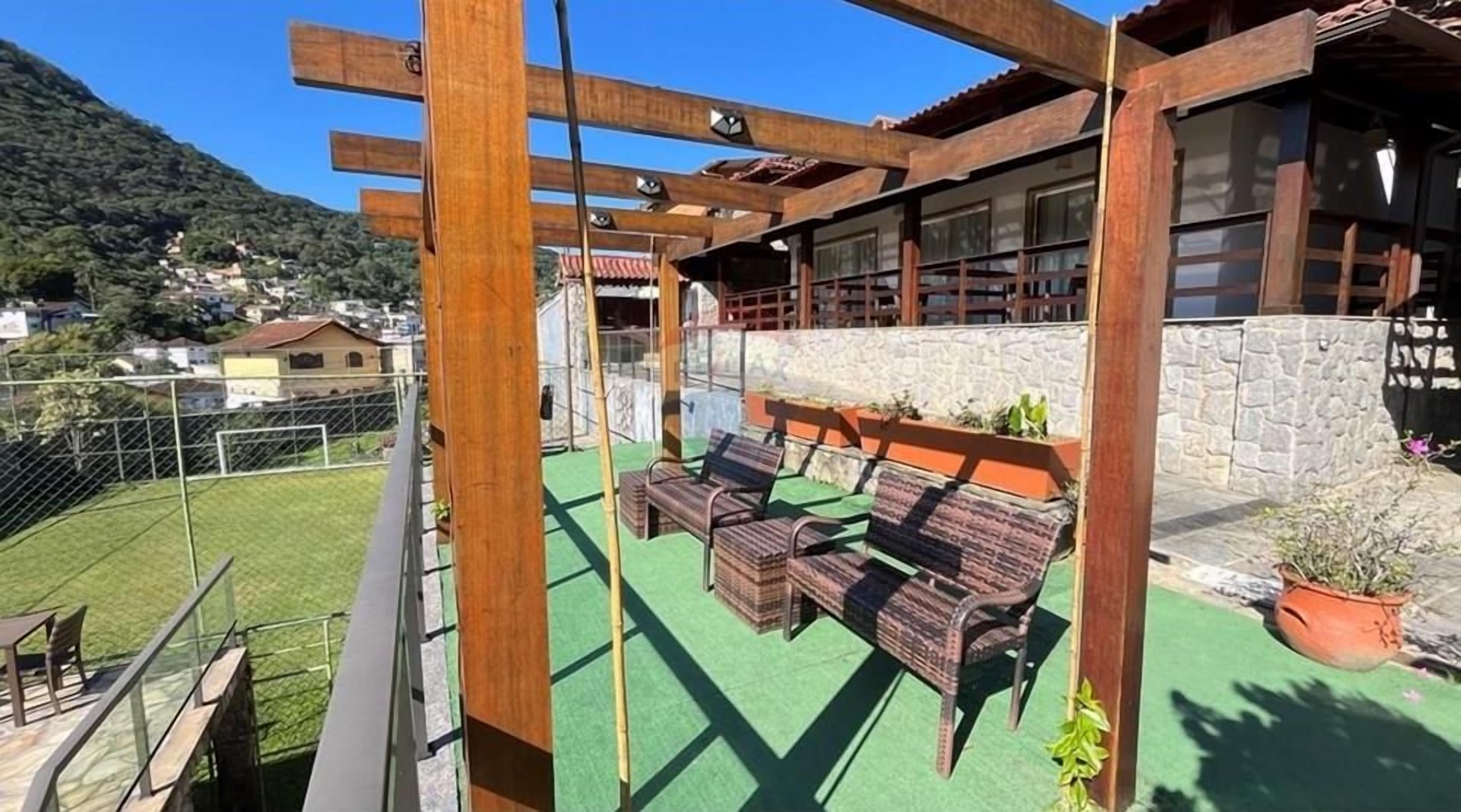 Een balkon met houten meubels en een stenen muur.