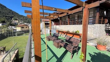 Een balkon met houten meubels en een stenen muur.