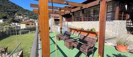 A balcony with wooden furniture and a stone wall.
