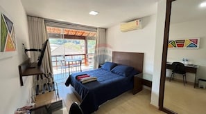 A hotel room with a bed, a desk, a chair, a TV, and a balcony with a view.