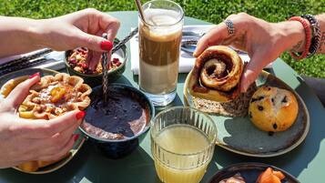 A table with food and drinks, outdoors on a sunny day.