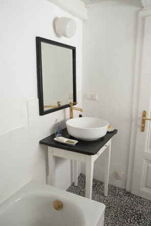 A bathroom with a white sink, black countertop, and a white bathtub. - The Fritsch-Weinbauernhaus in the countryside (Klein-Reinprechtsdorf)