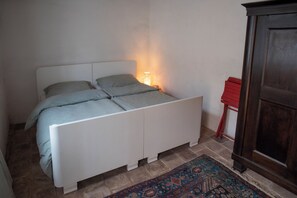 A bedroom with a bed, a nightstand, a lamp, and a wardrobe. - theFritsch-Weinbauernhaus in the countryside (Klein-Reinprechtsdorf)