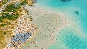 An aerial view of a coastal area with a beach, a small island with a tower, and a road leading to the beach. - Relaxing Le Residenze del Maria Rosaria No2227h (Orosei)