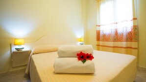 A hotel room with a bed, two bedside lamps, and a window with curtains. - Relaxing Le Residenze del Maria Rosaria No2227h (Orosei)