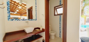 Un baño con lavamanos blanco, un espejo y un inodoro.