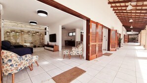 A spacious living area with a sofa, chairs, a TV, and a stone wall.