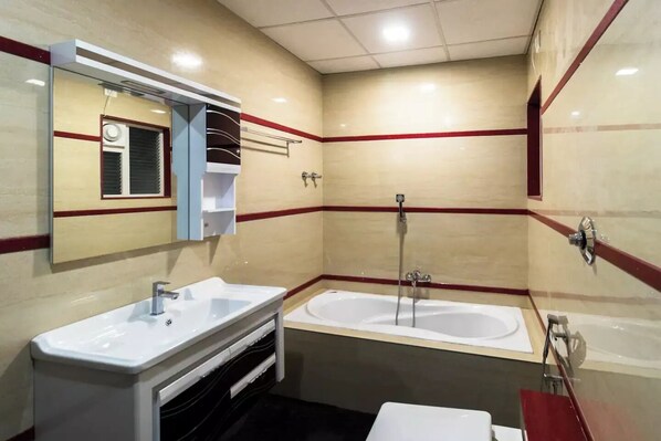 A bathroom with two sinks, a bathtub, and a shower.